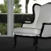 Белое кресло с темным кантом.