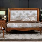 Белоснежная кровать и уютный стул с подлокотниками.