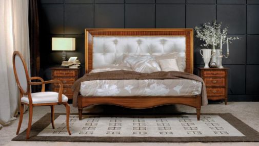 Белоснежная кровать и уютный стул с подлокотниками.