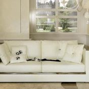 Белый диван с зеркальными подлокотниками.