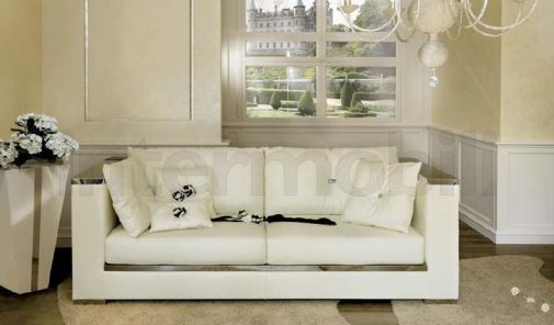 Белый диван с зеркальными подлокотниками.