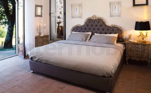 Двуспальная кровать с мягким изголовьем и стильные детали для спальни