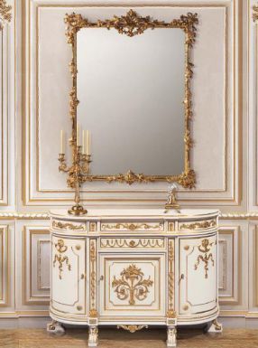 Комод и роскошное зеркало в золотой раме.