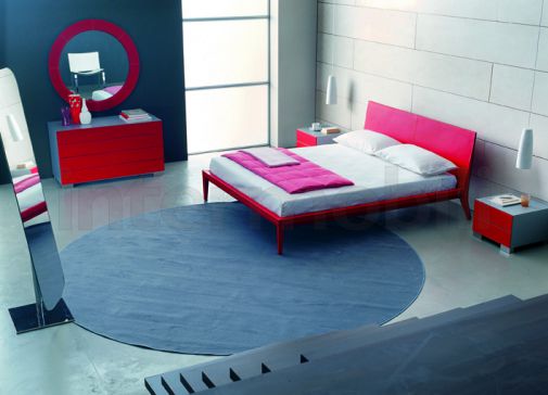 Красная кровать на деревянных ножках.