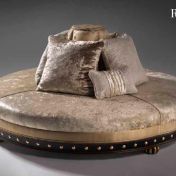 Круглый диван светлого оттенка.