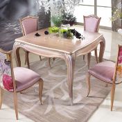 Квадратный стол и яркие стулья для столовой.