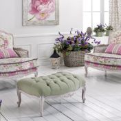 Мягкие кресла и пуф с цветочным принтом.