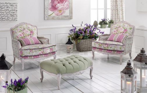 Мягкие кресла и пуф с цветочным принтом.