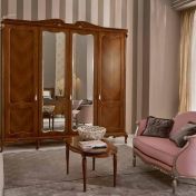 Шкаф для одежды и розовый диван.