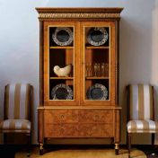 Витрина со стеклянными дверцами и мягкие стулья.